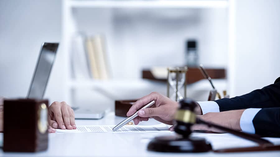 Ein Anwalt zeigt mit einem Stift auf ein Dokument
