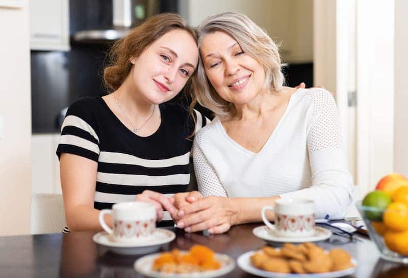 Eine Mutter und ihr Kind sitzen nebeneinander, sie profitieren von der Vermietung an Angehörige