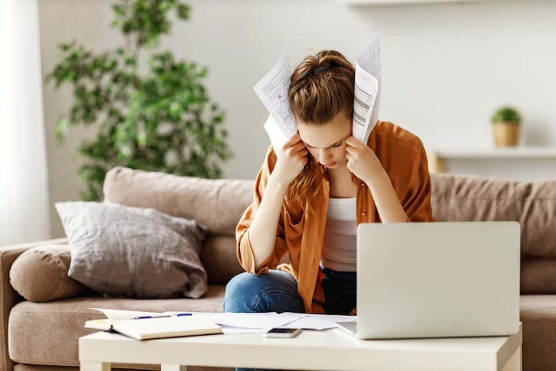 Eine Frau sucht am Tisch ihre Unterlagen heraus, welche sie für die Baufinanzierung benötigt