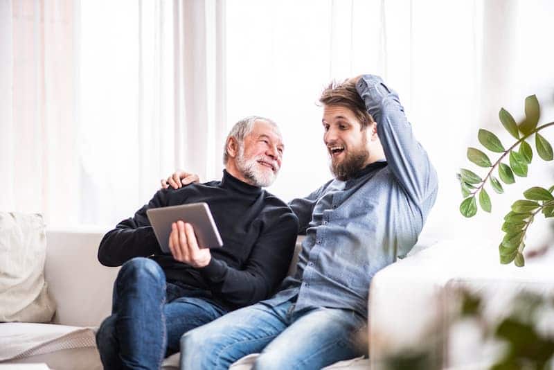 Mann sitzt mit Sohn auf dem Sofa, er möchte das Wohnrecht vererben