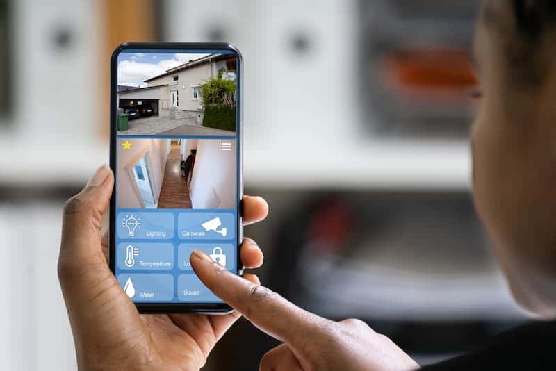 Eine Frau bedient eine App mit Smart-Home-Sicherheitsfunktionen