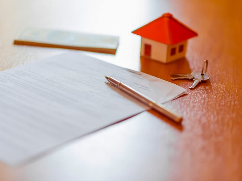 Ein Dokument mit einem Modellhaus und Schlüssel, welche Kündigungsfrist gibt es bei Mietwohnungen