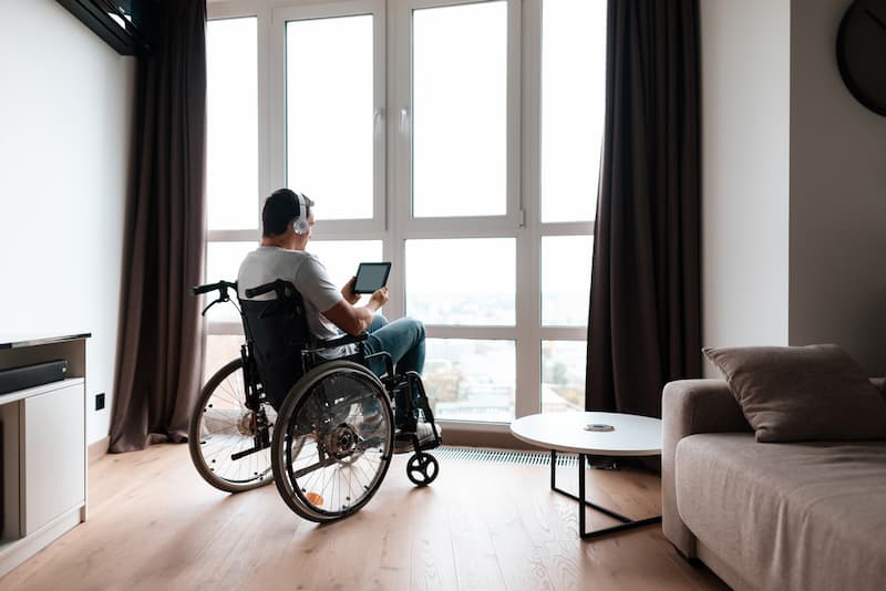 Ein Mensch im Rollstuhl, er benötigt eine barrierefreie Wohnung