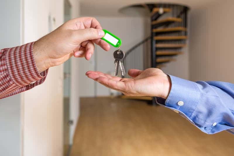 Ein Mann erhält die Schlüssel für eine Maisonettewohnung