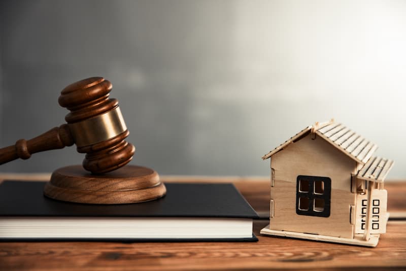 Ein Richterhammer, Buch und ein Haus als Symbole für das Wohnraumförderungsgesetz